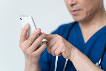 スマートフォンを操作する50代医療従事者