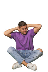 Casual man sitting on floor feeling confident, with hands behind the head.