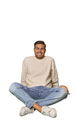 Young Caucasian man sitting on the floor in a studio setting