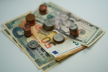 Overview of various dollar, euro and yen bills and coins of different currencies as a concept of saving and buying foreign currency