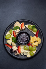 Cheese plate with crackers, nuts and herbs on white background