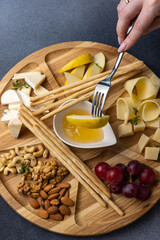 Cheese plate with crackers, nuts and herbs on white background