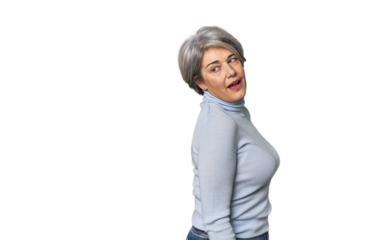 Caucasian mid-age female on studio background looks aside smiling, cheerful and pleasant.