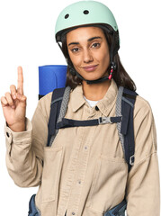 Hispanic young woman with mountain gear showing number one with finger.