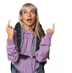 Young caucasian woman ready to hike pointing upside with opened mouth.