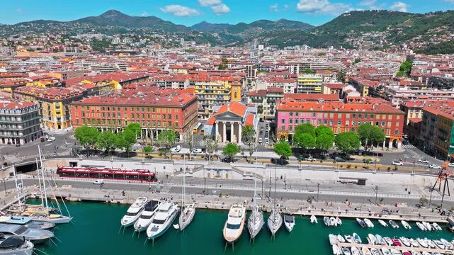 Aerial view of Nice Port with yachts and sailboats docked at the harbour. View from above of Marina on the French Riviera with colourful boats and buildings. Luxury resort town on the Cote d'Azur.
