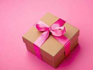 Obraz premium A brown gift box wrapped in a pink ribbon, sitting on a pink background