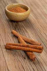cinnamon sticks and powder on wooden background