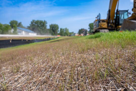Woven straw mat used for stormwater erosion control with grass growing through 
