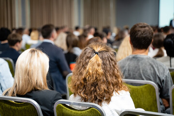 In a bright conference room with vibrant green chairs, a diverse group engages in lively...