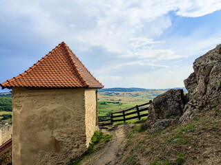 Old Fortress in Transylvania, Romania. Stone Wall of ancient fortress with tower.  Sky is blue with white clouds. Copy space. Selective focus.