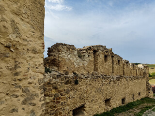 Part of old limestone and stone wall of an ancient fortress, against cloudy sky. Copy space....