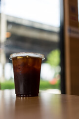 Closeup shot of a plastic glass of black coffee on tabel
