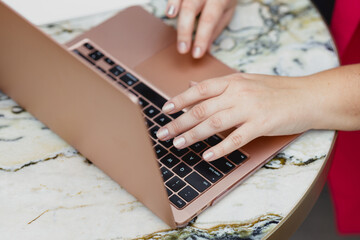Close up woman typing on a laptop
