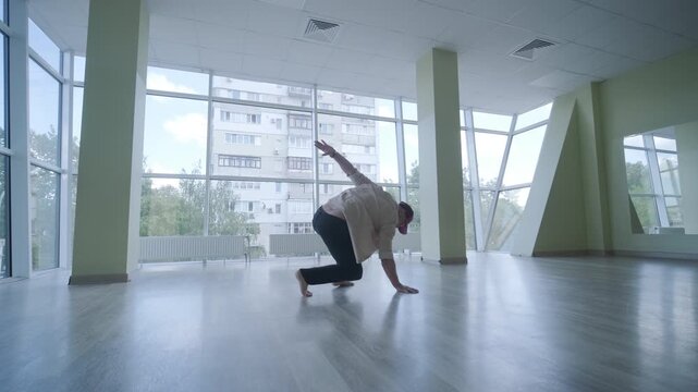 Stylish young man dancing break dance and choreography. Performance, movement, style and fashion concept