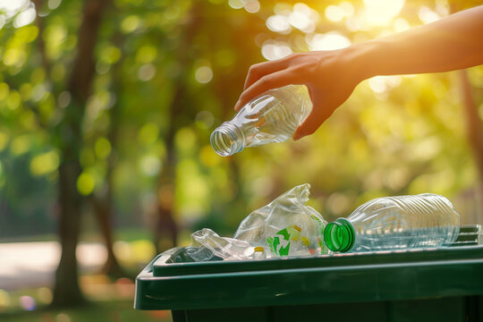 Hand Placing a Plastic Bottle into a Recycling Bin Outdoors