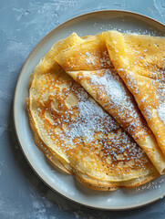 Delicious crepes topped with powdered sugar on a plate