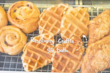 Variety of baked products at a bakery shop,pastries in a bakery window,bakery brown breads to sell,Different types of bread loaves on bakery shelves,Real photo,Template,Copy text space.