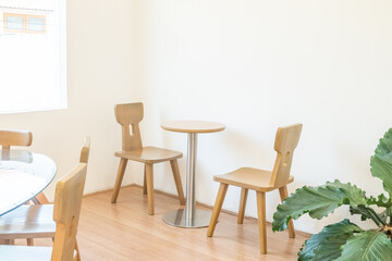Empty wooden chairs and table in dining room,tropical plants and elegant personal accessories in stylish home decor,Template..