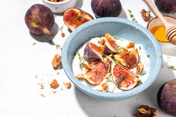 Creamy rich and tasty yogurt dessert with autumn figs, granola, honey, nuts. Healthy balanced snack or breakfast bowl, copy space