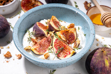 Creamy rich and tasty yogurt dessert with autumn figs, granola, honey, nuts. Healthy balanced snack or breakfast bowl, copy space