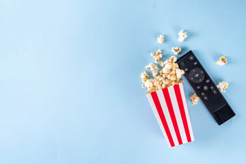 Paper bowl buckets of popcorn with TV remote on colorful bright background. Enjoy of watching TV,...