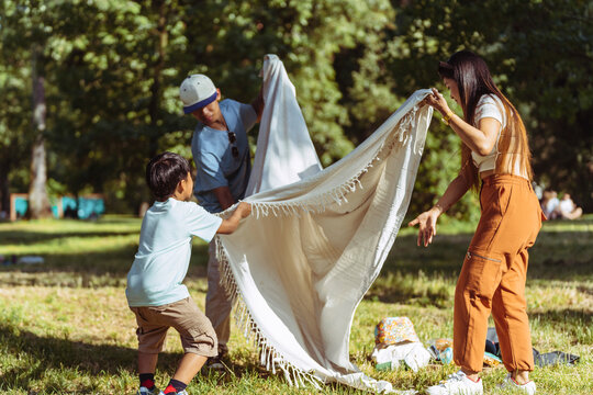 Asian family enjoying a sunny picnic in a lush park