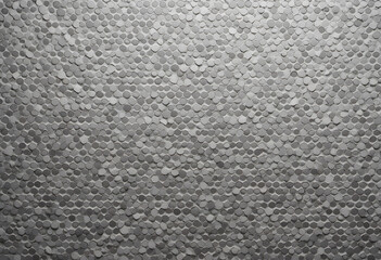 A textured wall made of small hexagonal tiles in various shades of gray, creating a modern and stylish appearance.