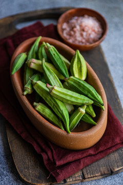 Raw bamia pods in a rustic bowl, ready for Mediterranean cooking