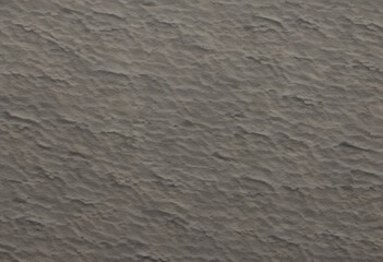 Obraz premium A textured surface with a subtle, wavy pattern in neutral gray tones. The surface appears slightly rough, adding depth and interest.