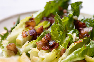 Close up of cos lettuce salad with crispy bacon, and parmesan cheese. Easy healthy recipes.