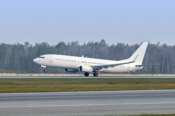 Naklejka premium Modern white passenger airliner takes off runway