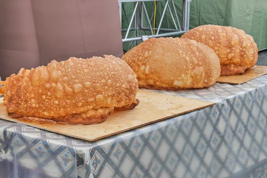 Three huge baursaks lying on table during Biggest Baursak competition. Tatar gastronomic festival