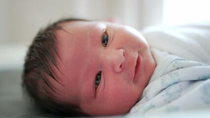 Newborn baby close-up face capturing the first days o flife life of an infant observing the world around him, first week of life