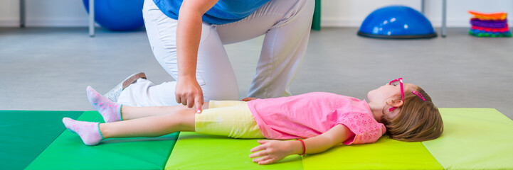 Child with physical disability in physical therapy session. Child living with cerebral palsy...