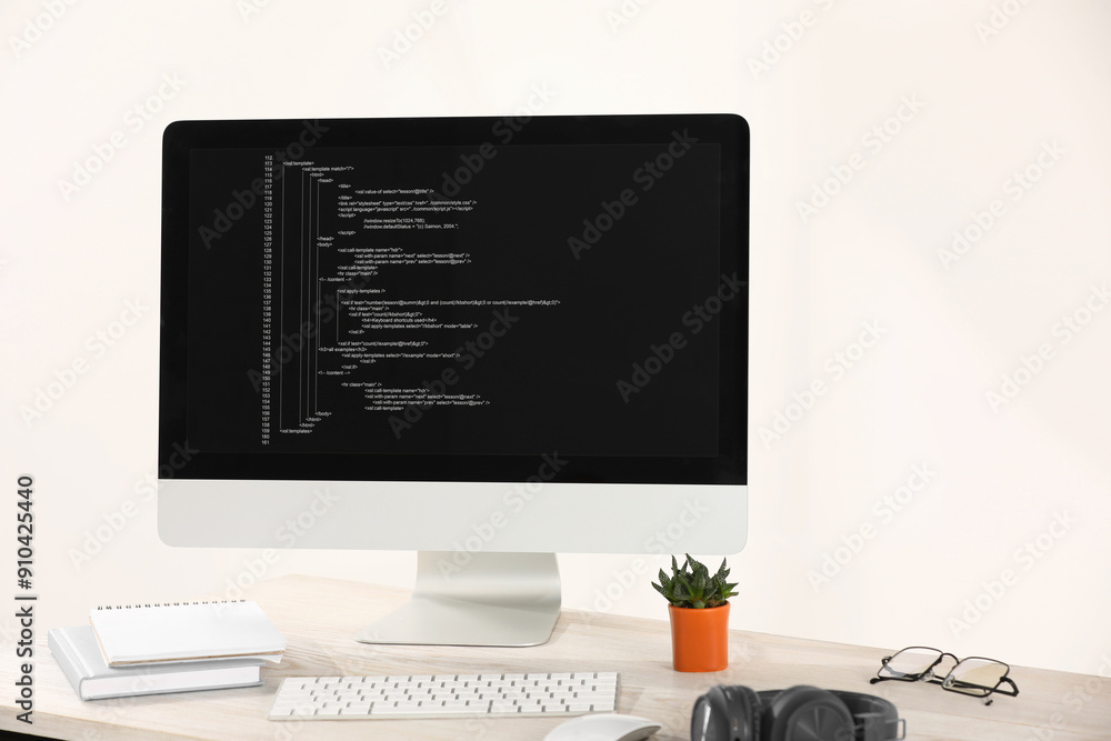Poster programmer's workplace. modern computer with unfinished code, headphones and supplies on desk