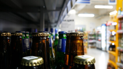 Close-up of many glass beer bottles in a grocery store
