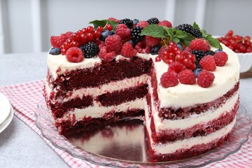 Tasty sponge cake with different berries on light grey table