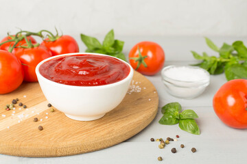 Delicious ketchup with spices and tomatoes on wooden table