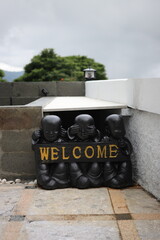 three statues with welcome sriting