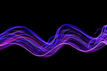 Light Painting Photography - swirly waves of neon purple light against a black background. Long exposure photograph. 