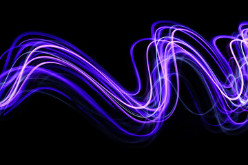 Light Painting Photography - swirly waves of neon purple light against a black background. Long exposure photograph. 