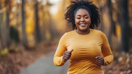 Happy curvy woman running in a forest during autumn