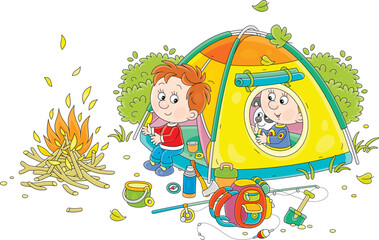 Naklejka premium Cheerful little kids tourists with a merry pup resting in their camp tent by a campfire, vector cartoon illustration