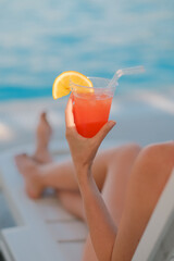 Girl in a sun lounger holding a cocktail