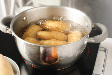 Boiling potatoes in metal pot on stove