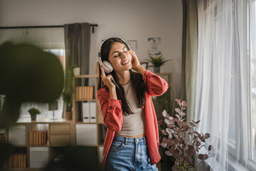 Adult woman prepare to put headphones and listen to music on cellphone