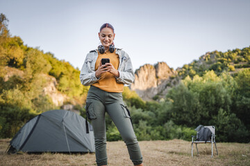 portrait of young woman with headphones stand and use cellphone