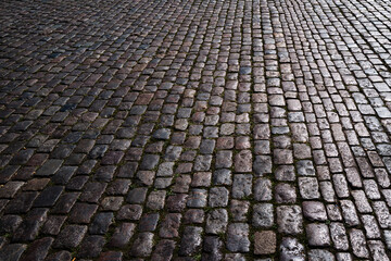 Fototapeta premium Stone road. Pavement texture. Stonework background for design. Granite cobblestoned pavement background. Abstract background of cobblestone pavement.