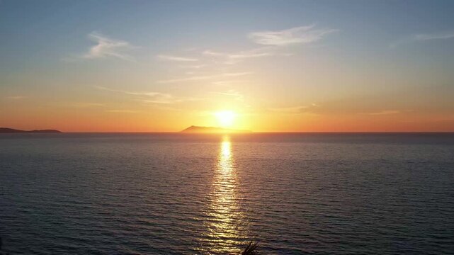 Flug an der K&uuml;ste von Korfu &uuml;ber das Meer in Richtung der untergehenden Sonne